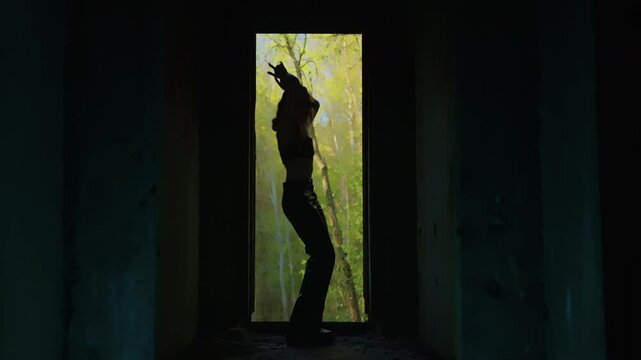 girl in silhouette gracefully dances. girl dance. body plasticity. dark frame