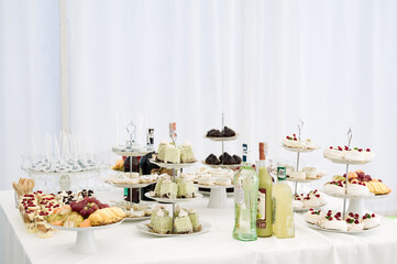 A lavish dessert spread featuring a variety of sweet treats, including cakes, pastries, and fresh fruit.  Bottles of liquor add a touch of sophistication.