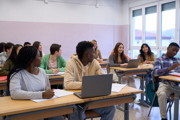 Multiethnic students studying together in modern classroom