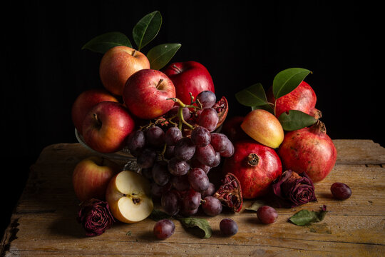 Still life with pomegranates, apples and grapes