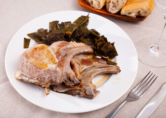 Delicious fried pork chops with stewed beans served at plate