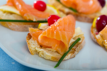 Mediterranean snack - bruschettes with salmon, butter and cranberries