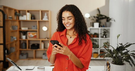 Smile, entrepreneur or woman with phone in startup for email in office for networking on social...