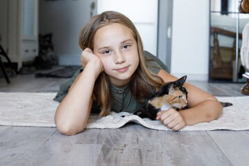 Cute young girl and cat pet together at home. Friendship and care