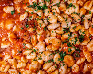 Close-up on gnocchi pasta in a rich red sauce 