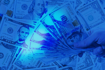 Fototapeta premium US Dollar cash money in uv light on blue background