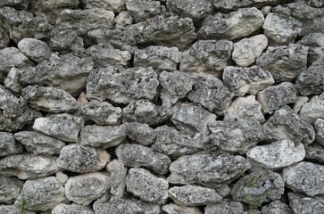 Old stone wall of unjoined rough white limestones closeup