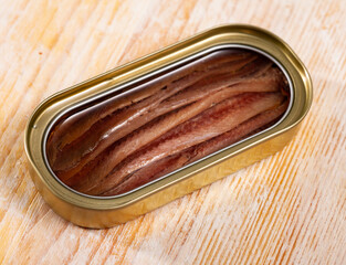 Close-up of canned anchovy fillet in oil on wooden surface, nobody