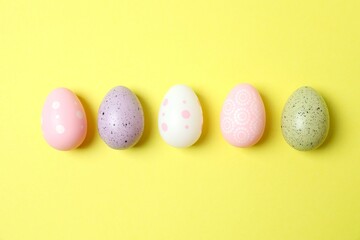 Happy Easter. Colorful eggs on yellow background, space for text or advertising
