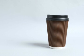 Paper cuз with plastic lid on light background. Coffee to go