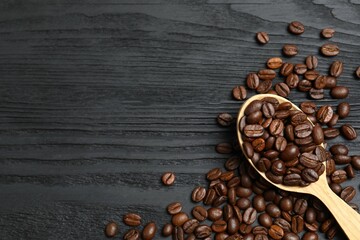 Fresh coffee beans in spoon on wooden background