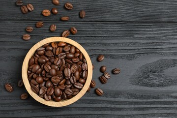 Fresh coffee beans in bowl on wooden background