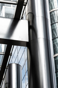 Steel and glass structural detail in a contemporary cityscape, emphasizing reflections and industrial aesthetics.