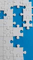 Fototapeta premium White puzzle pieces arranged on a blue backdrop with gaps, illustrating the concept of missing connections, teamwork and solving problems in a creative design.