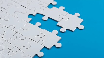 Fototapeta premium Incomplete white puzzle pieces on a vibrant blue surface, symbolizing the challenge of problem-solving, teamwork and the importance of connecting ideas.