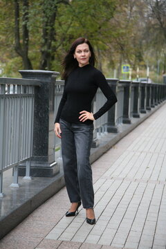 Age model woman 51 years old, brunette with loose hair, stands in a podium pose