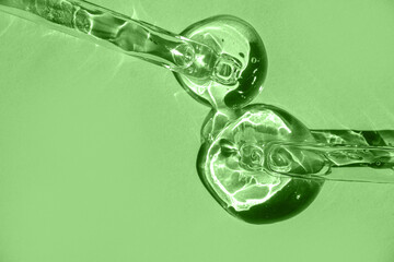 A close-up of a dropper with aloe vera gel, set against a vibrant green background.