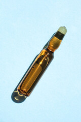 Ampoule of cosmetic gel on a blue background.