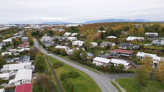A peaceful drone view of Hafnarfj&ouml;r&eth;ur with colorful autumn trees and hills, 4K
