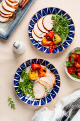 Baked turkey breast, sliced into thin slices on a plate with vegetables.