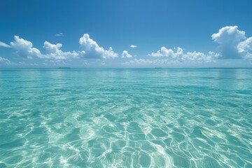 Serene turquoise ocean under a vibrant blue sky dotted with fluffy white clouds.