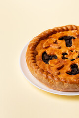 Tasty mushroom pie on a white ceramic plate from above view on beige background.