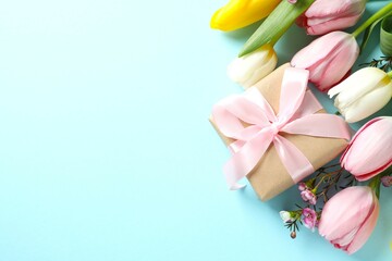 Beautiful fresh tulips with gift box on color background