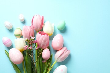 Colorful eggs with tulip flowers on a color background, space for your text or advertising. Happy Easter