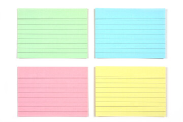 A top-down view of four colorful papers with horizontal lines, arranged in a grid pattern on a...