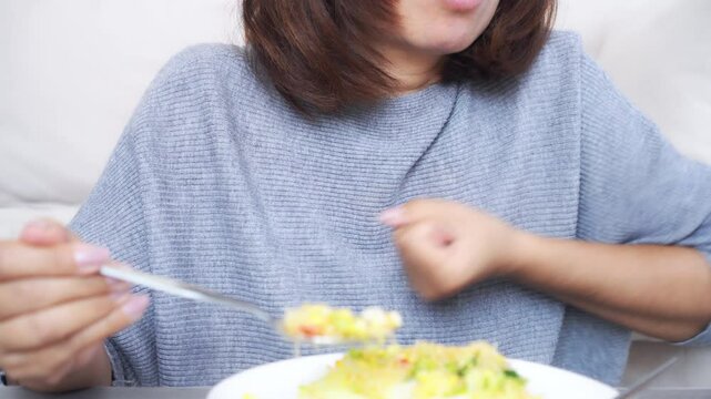 Asian woman experiencing a choking accident while eating, struggling with food stuck in her throat, coughing, and having difficulty breathing