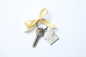 Metallic key with keychain in shape of house on white background