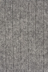 A detailed close-up shot of a knitted gray fabric texture with a ribbed pattern