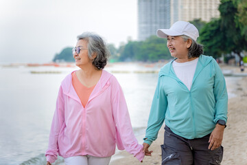 Obraz premium Two Asian elderly women are walking for exercise in the morning. by the seaside