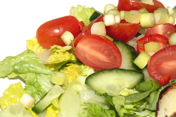Close up of a healthy cold salad chopped tomatoes and cucumbers on a whiite background