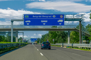 View of blue Belgrade directional sign and the traffic.