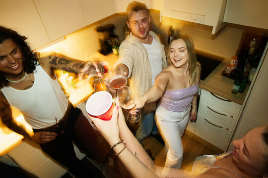 High angle view of friends toasting drinks during party at home