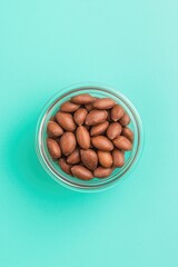 Nuts in clear jar against vibrant turquoise backdrop create fres