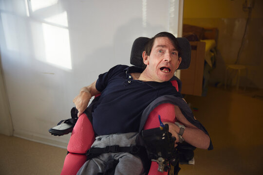 Mature man with physical disability sitting on wheelchair at nursing home