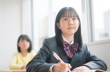 授業を受ける制服を着た女子中学生。
