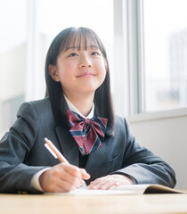 授業を受ける制服を着た女子中学生。
