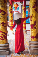 back of an Asian female tourist traveling in a temple on a pagoda in Vietnam in Asia