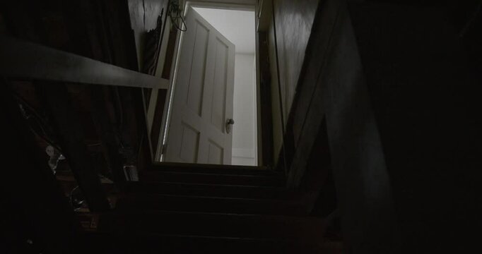 Wide Tilt Up Shot of a Dark and Creepy Basement Staircase