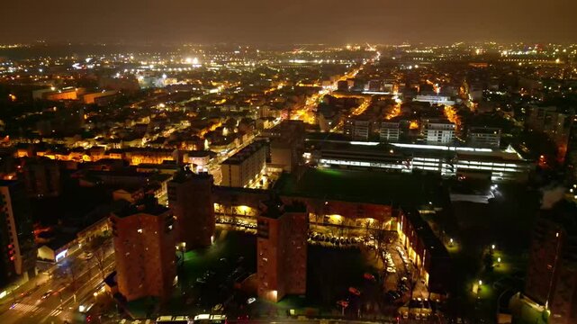 Panorama drone view of Aubervilliers night skyline with sprawling cityscape and slightly gloomy sky, Paris region, Seine Saint-Denis, France. Aerial drone forward and cityscape