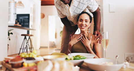 Happy couple, lunch or dining table with date for valentines day, anniversary or romantic dinner surprise at home. Interracial, man or woman with smile, champagne or meal for love, care or romance