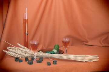 still life two glasses and alcohol meter with homemade tincture,  cucumber and ears of wheat