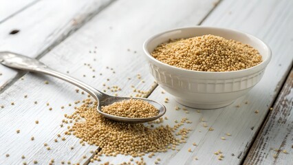 Golden Grains: A close-up shot of a bowl filled with golden grains and a spoon on a rustic wooden surface, representing health, nutrition and organic eating.