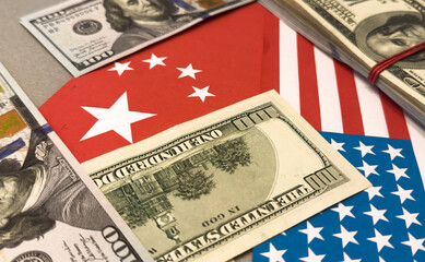 Us and china flags with currency symbolizing economic relations.