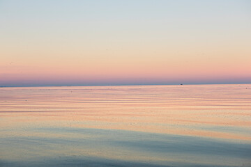 calm sea surface in different shades of pink and lilac at sunset. minimalist sea calm landscape