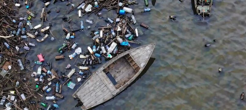Abandoned boat amidst river pollution highlighting environmental crisis