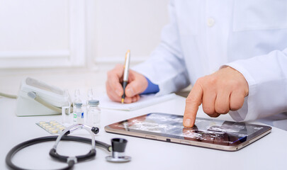 Fototapeta premium Medical professional uses tablet to document patient information in clinical setting